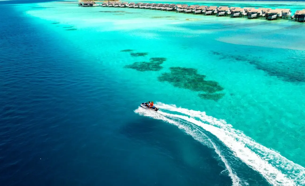 An all-inclusive that includes the transfer — the activity/scene in action. The INDULGENCE plan, with the speedboat from Malé folded in.
