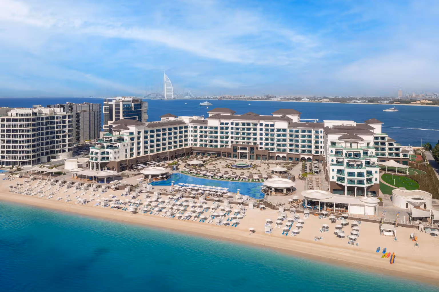Hero/establishing shot of Taj Exotica Resort & Spa, The Palm, Dubai. Indian ‘Tajness’ hospitality on Palm Jumeirah’s East Crescent — 325 rooms and suites, the longest pool on the crescent at around 70 metres, and standout Indian fine dining at Varq with rooftop skyline dining at Raia.
