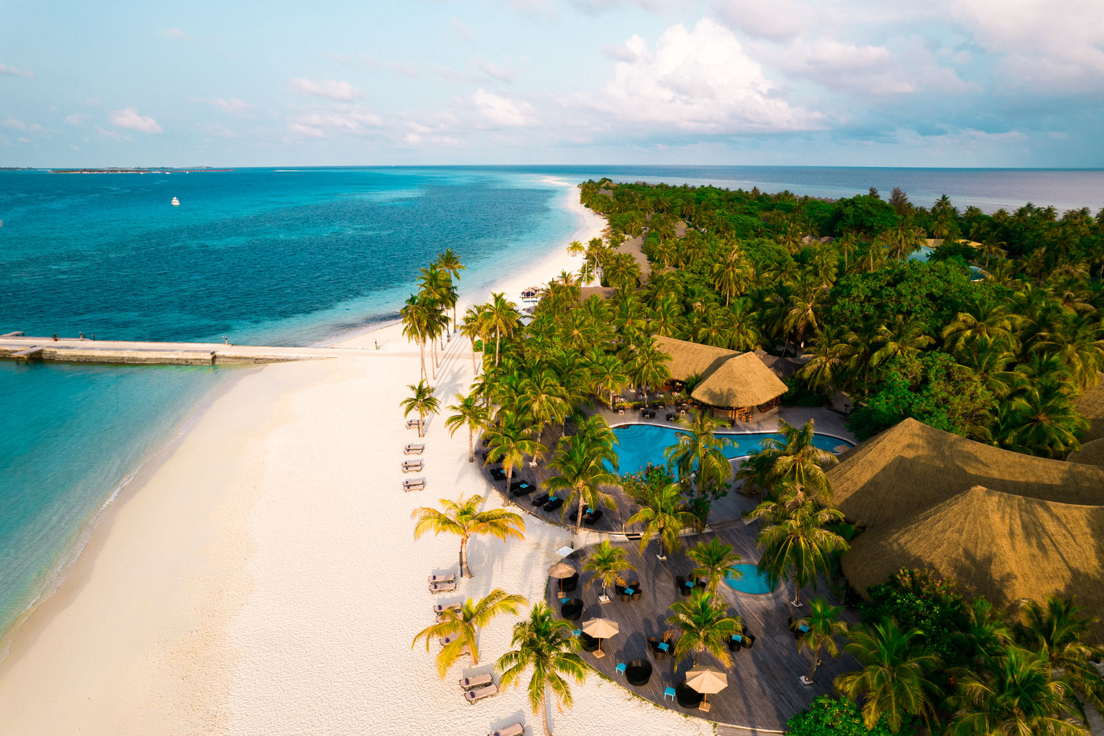 Signature hero of Kuredu Island Resort & Spa (Lhaviyani Atoll, Maldives): the single most iconic wide view — The original diving island, Space & value, Adults & family zones. Golden-hour, landscape, room to overlay text.