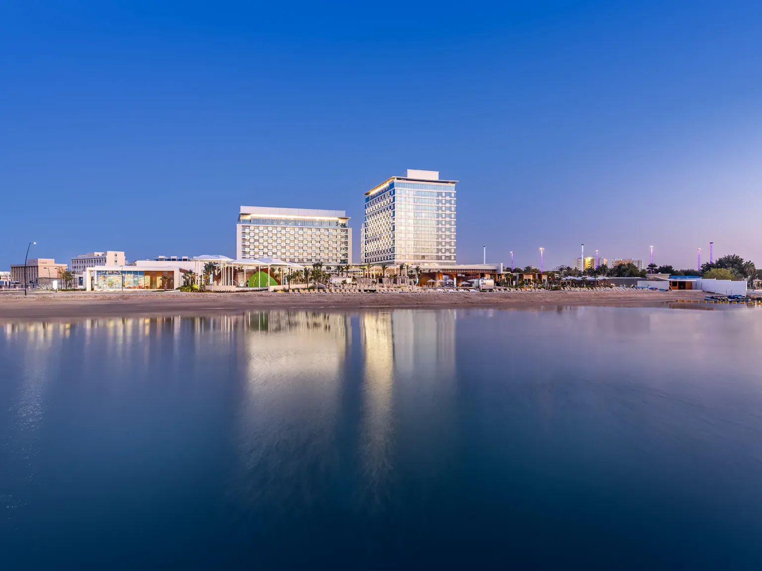 Hero/establishing shot of Rixos Gulf Hotel Doha, Doha, Qatar. Qatar’s first all-inclusive beach resort — set in an iconic 1973 heritage building (the country’s first five-star hotel), reimagined under the Rixos all-inclusive concept on a central Doha beachfront.