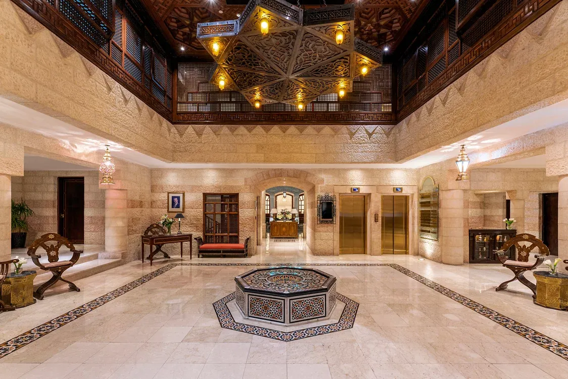 Hero/establishing shot of Mövenpick Resort Petra, Petra, Jordan. The Petra base — a heritage resort directly opposite the Petra visitor centre, around fifty metres from the gate, with Arabesque interiors, antiques and handcrafted wood.