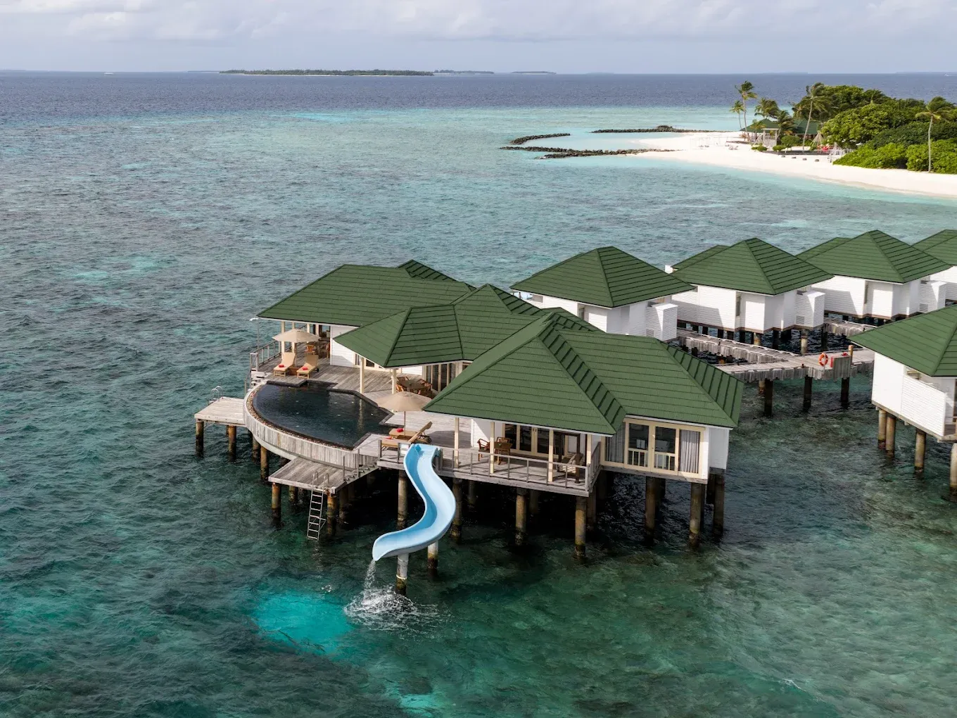 Signature hero of Siyam World (Noonu Atoll, Maldives): the single most iconic wide view — Largest resort, Water park & activities, All-inclusive. Golden-hour, landscape, room to overlay text.