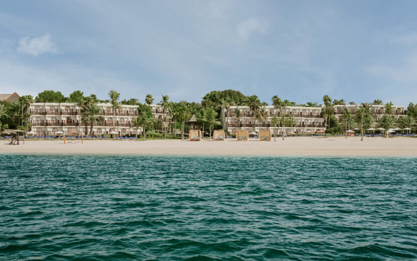 Hero/establishing shot of JA Palm Tree Court, Dubai. An all-suite, all-inclusive-capable family beach resort in the 128-acre JA The Resort estate at Mina Jebel Ali — one of Dubai’s few genuine all-inclusive options.