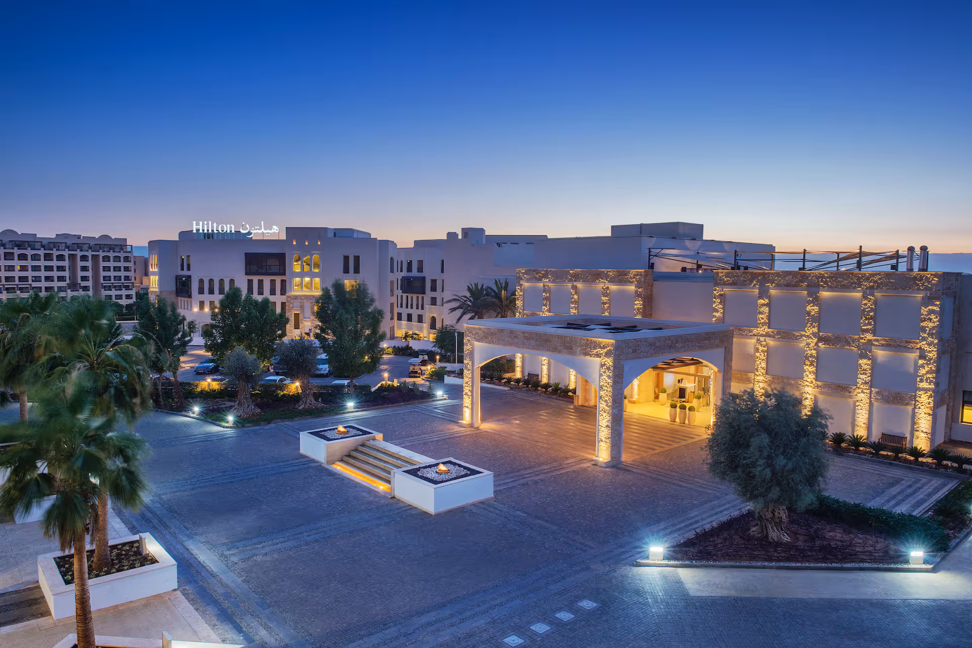 Hero/establishing shot of Hilton Dead Sea Resort & Spa, Dead Sea, Jordan. A contemporary, family-first Dead Sea resort on the Jordanian shore at Sweimeh, with a dramatic Siq-like gorge lift down to the beach and the area’s only floating sun deck.