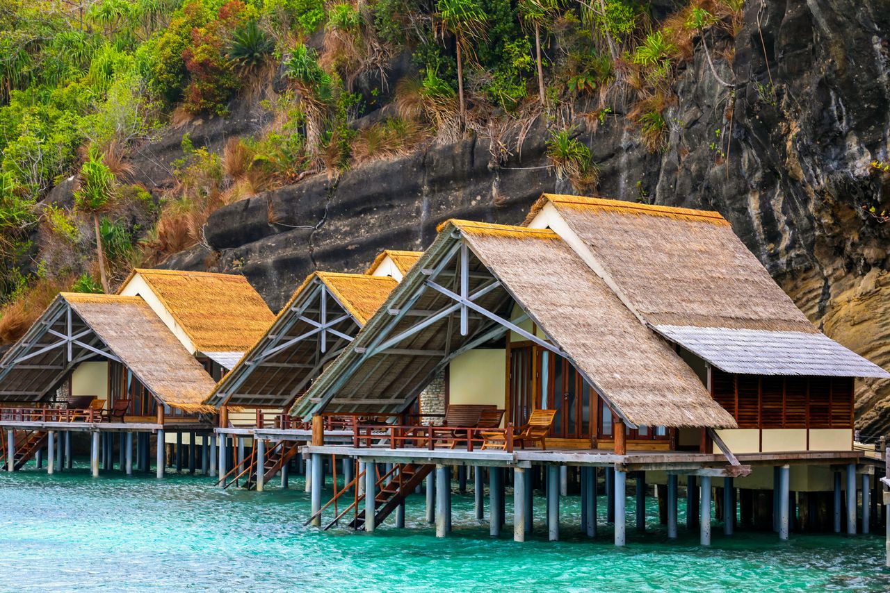 Stepping from your private deck straight into the lagoon, breakfast arriving by canoe, the water glowing turquoise beneath the floor