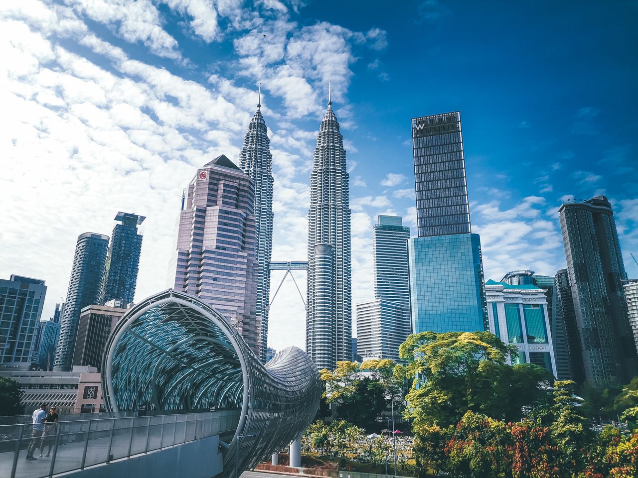 The Petronas Towers, the street-food and temples of the old quarter, and rooftop bars with a skyline view